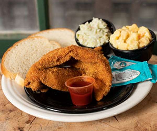 Fried fish with sides of mac and cheese and cole slaw